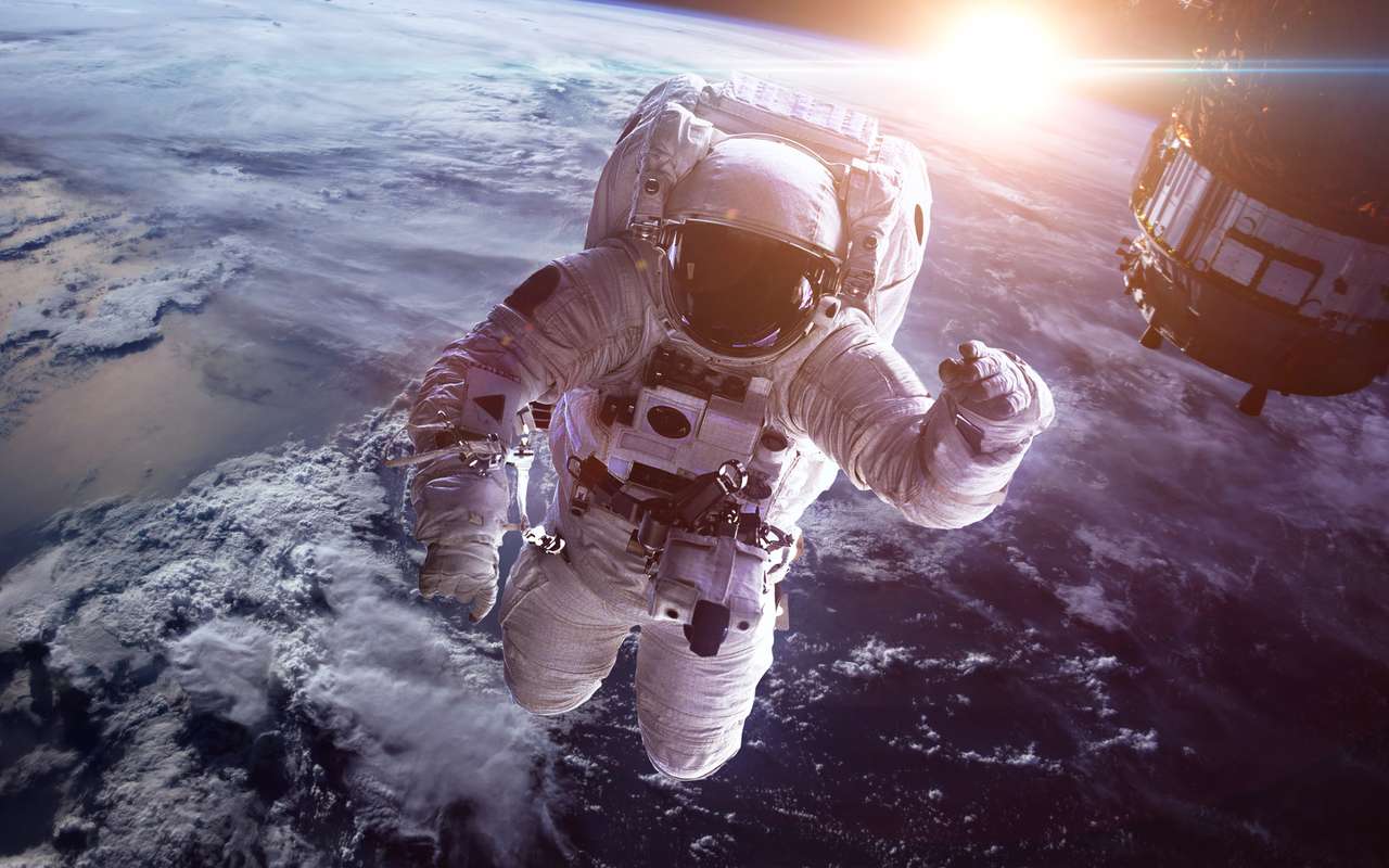 Astronauta w przestrzeni kosmicznej na tle planety Ziemia puzzle online