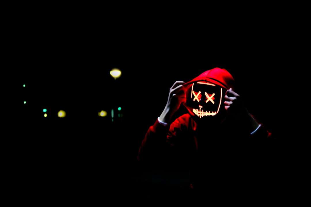 osoba nosząca bluzę z kapturem i neonową maskę puzzle online
