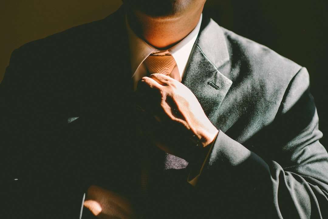 Mężczyzna w czarnym garniturze rozluźniający krawat puzzle online