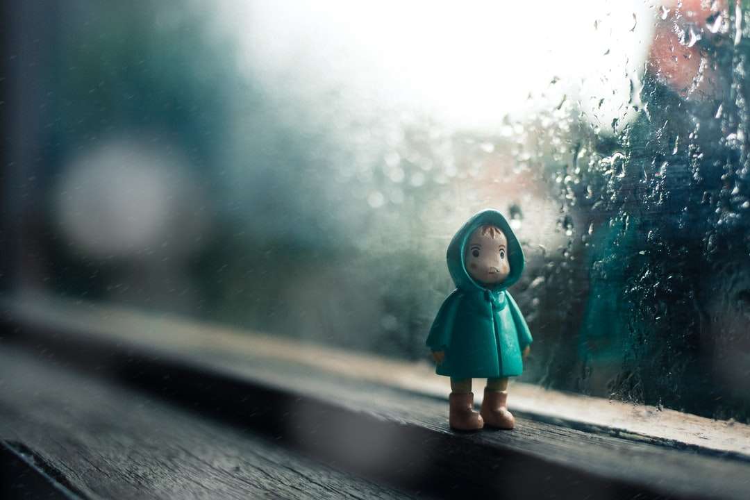 Kid noszenie zielonej kurtki mini figura obok okna szkła puzzle online