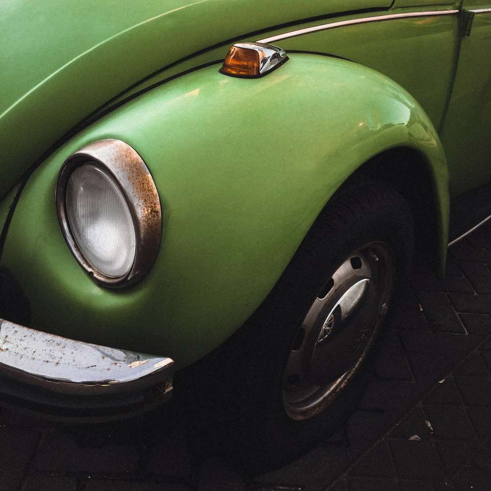 Zielony Volkswagen Beetle na czarnej ceglanej podłodze puzzle online