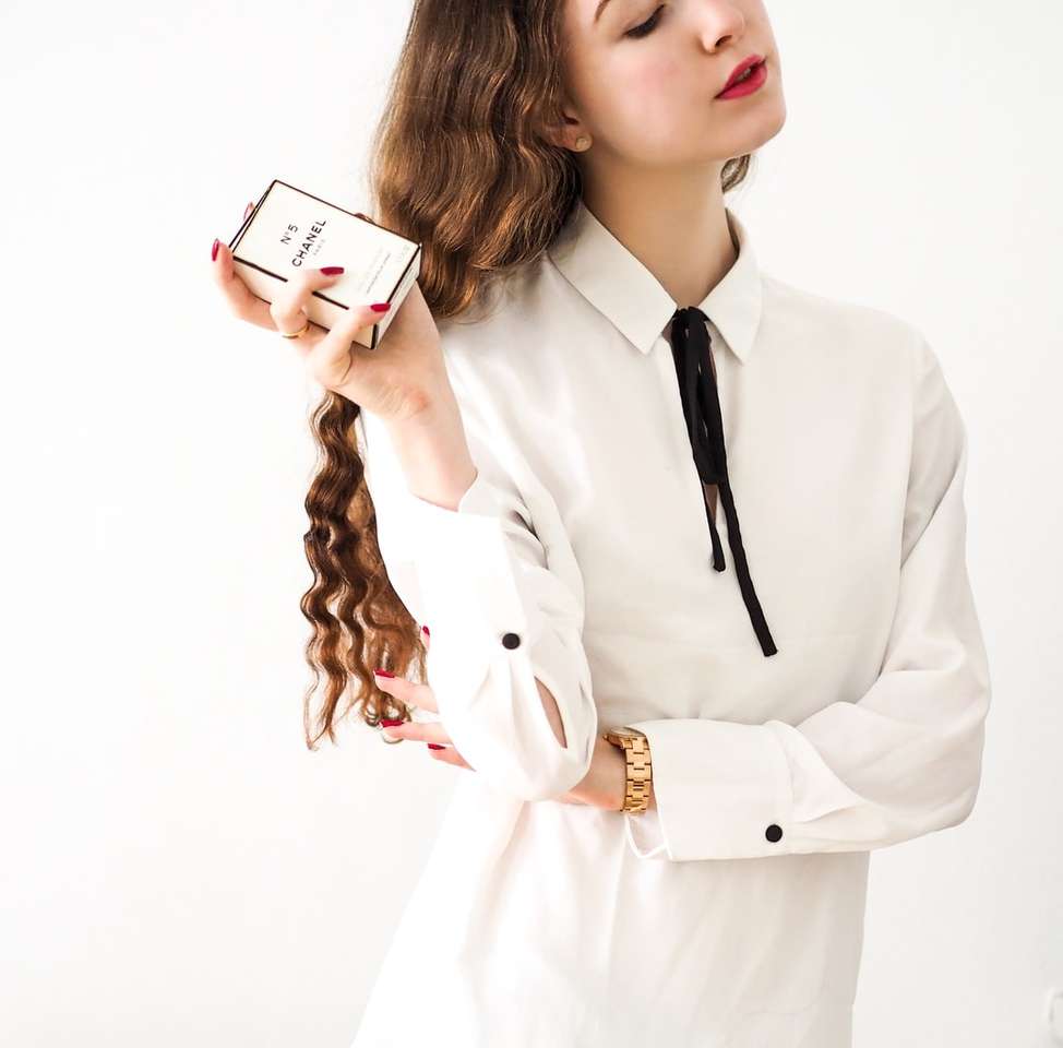 kobieta w białej marynarce trzymająca biały smartfon puzzle online