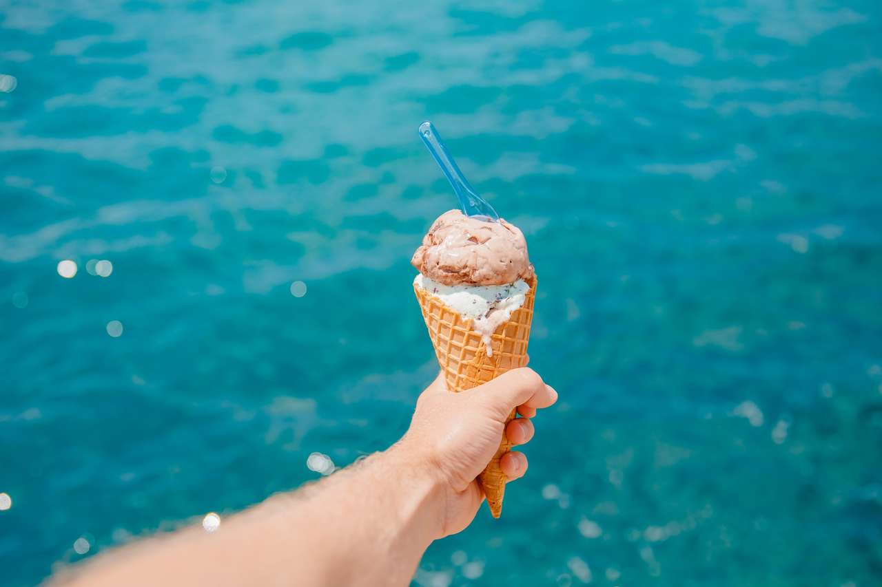 Сладолед в конус с лъжица срещу синьо море пъзел