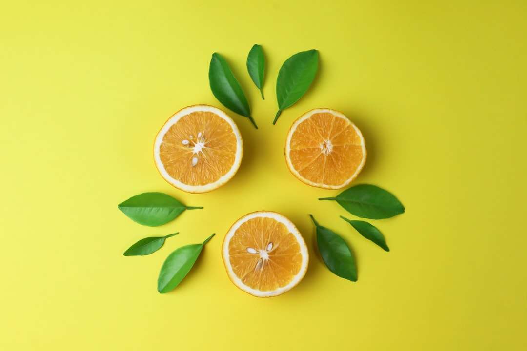 Pokrojona pomarańczowa owoc na żółtej powierzchni puzzle online