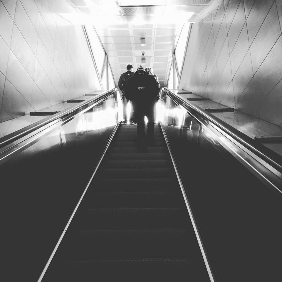 fotografia w skali szarości przedstawiająca mężczyznę na schodach ruchomych puzzle online