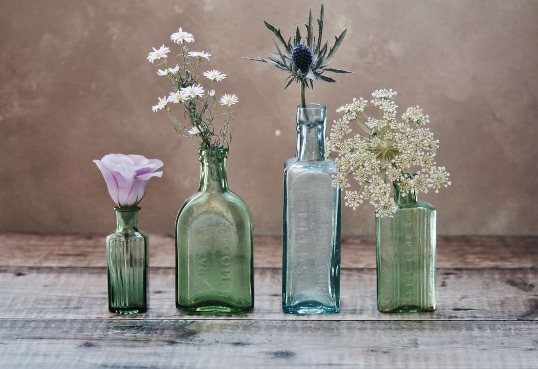 Trzy zielone i jedno niebieskie szklane wazony z kwiatami wewnątrz puzzle online
