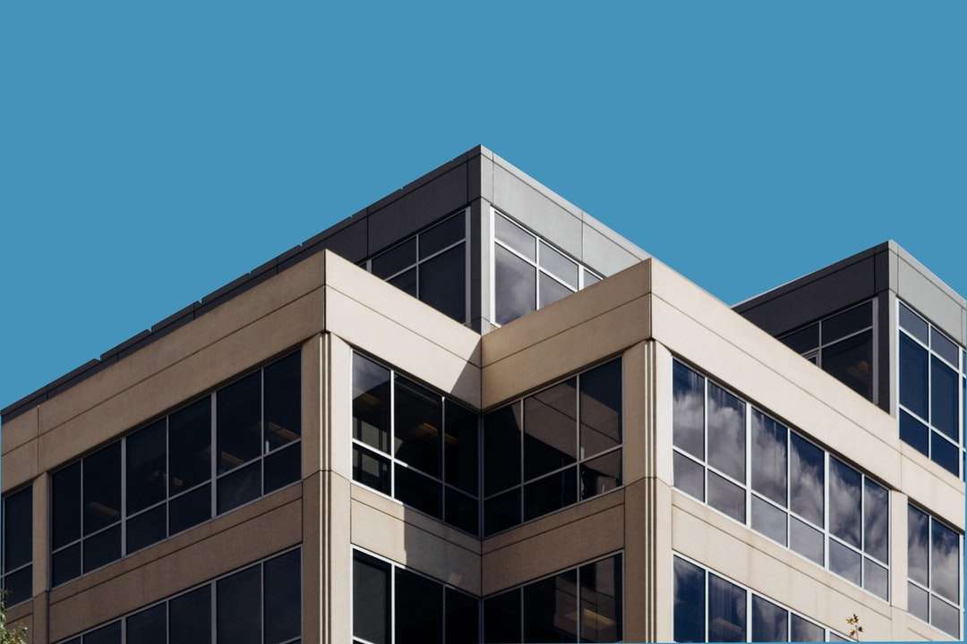 Brązowy betonowy budynek pod błękitnym niebem w ciągu dnia puzzle online