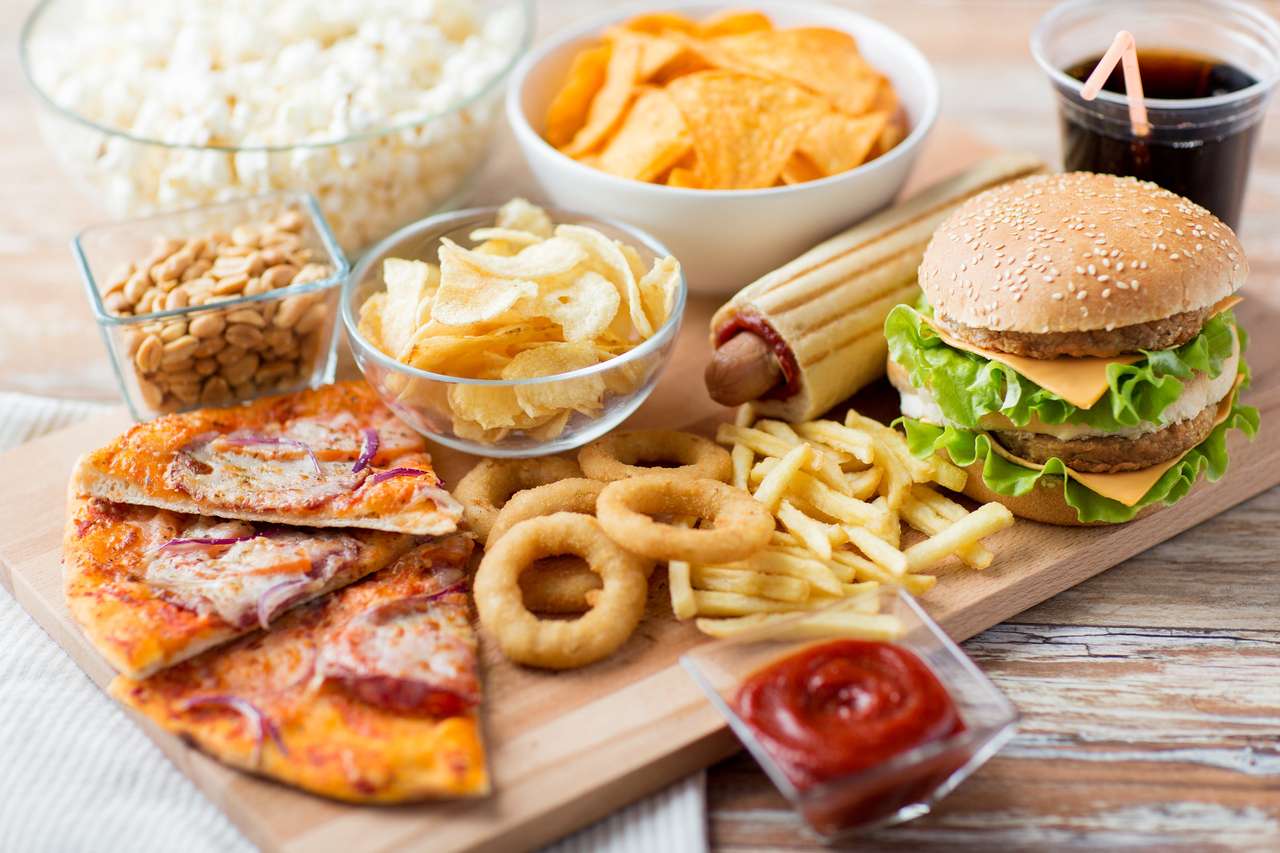 Fast food i niezdrowy jedzenie koncepcja - Zamknij się fast food przekąski i pić koli na drewnianym stole puzzle online