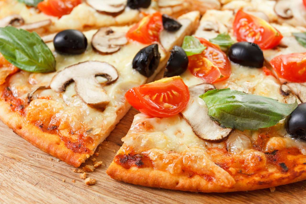 Pokrojona pizza z grzybami, oliwkami i pomidorami. Basil, rozmaryn i świeże warzywa. Świeżo domowej roboty puzzle online