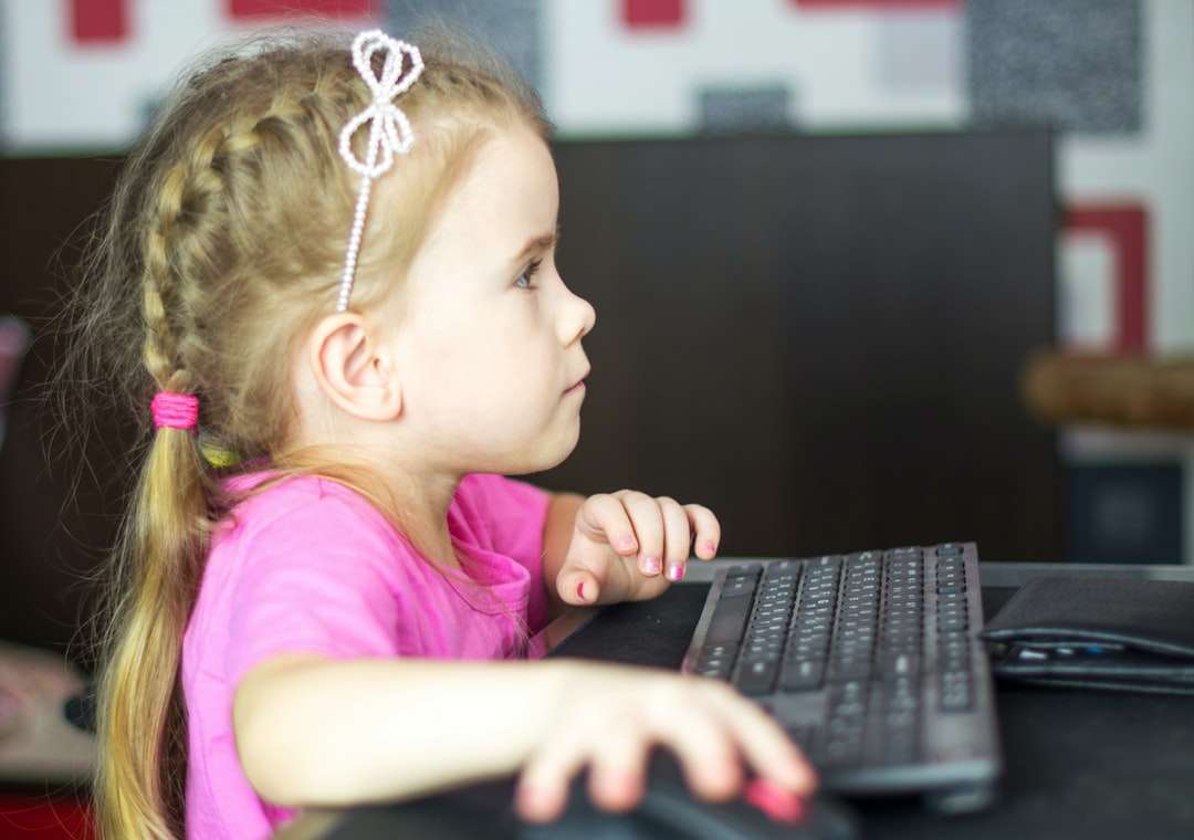 dziewczyna w różowej koszuli korzystająca z czarnego laptopa puzzle online