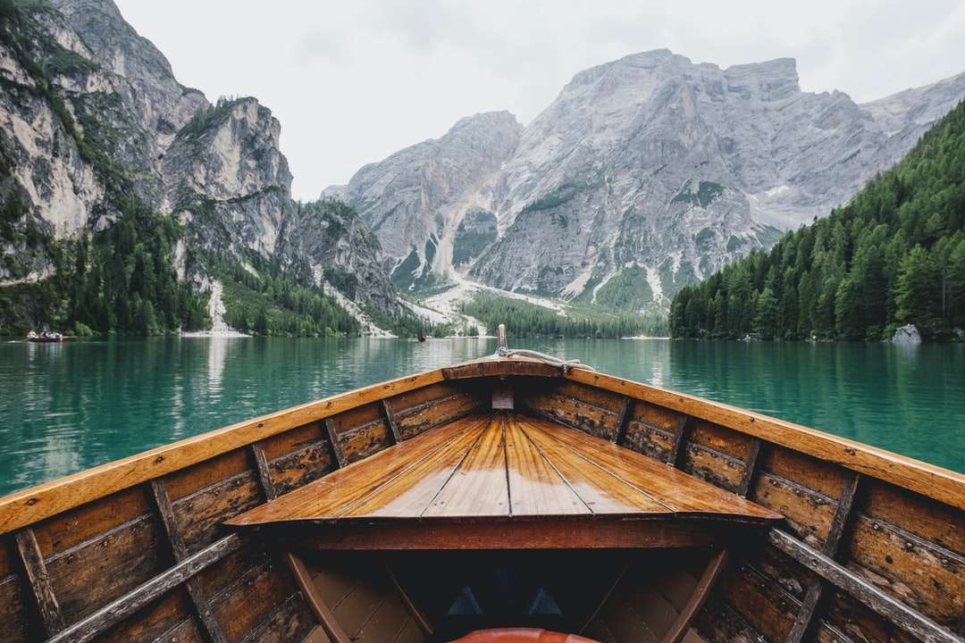 Brązowa drewniana łódź poruszająca się w kierunku góry puzzle online