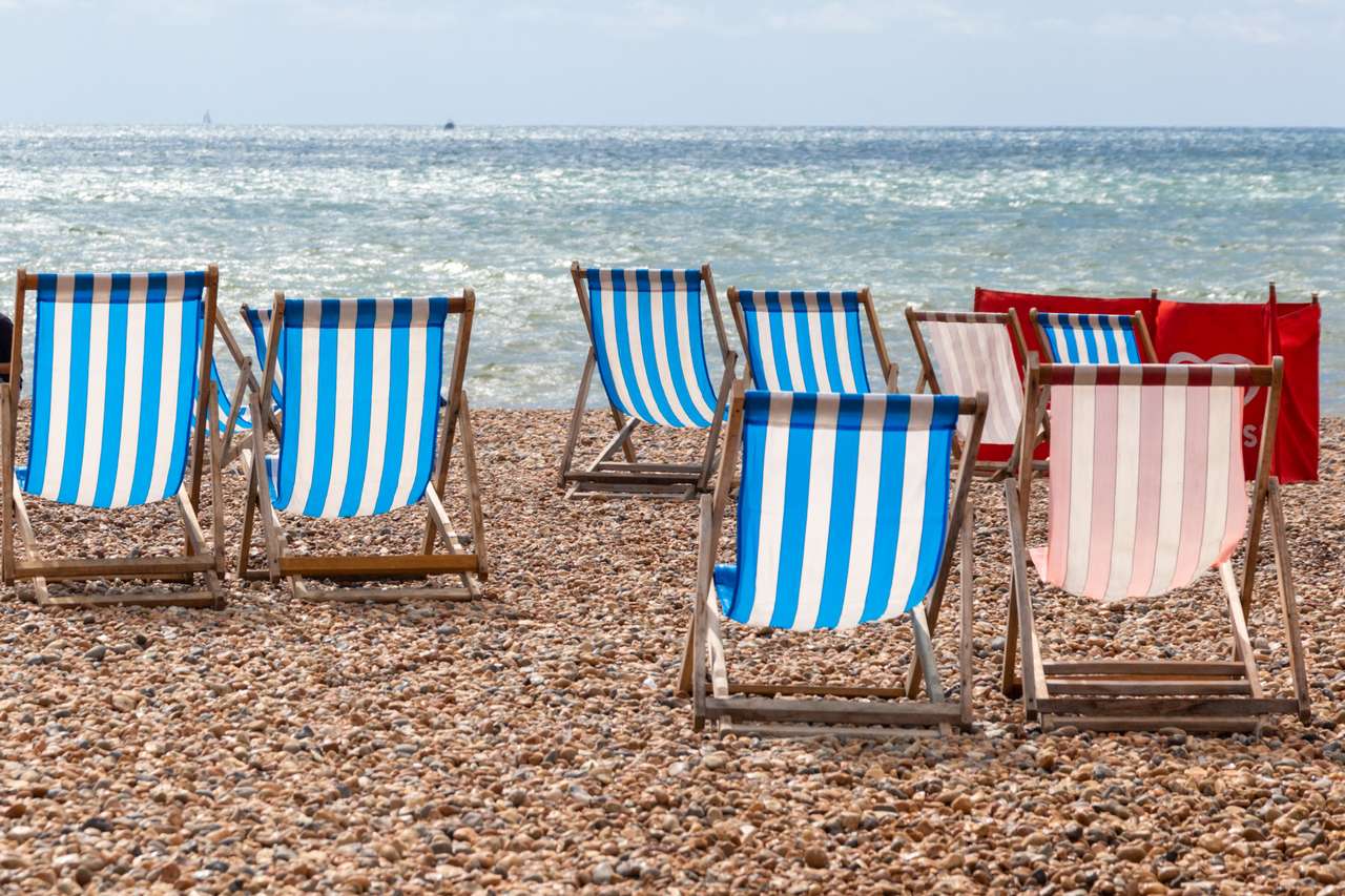 Kolorowe paski leżaki do wynajęcia na plaży żwirowej w Brighton, East Sussex, Anglia puzzle online