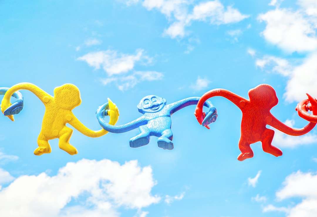 Trzy różnorodne małpy plastikowe zabawki trzymające się nawzajem puzzle online