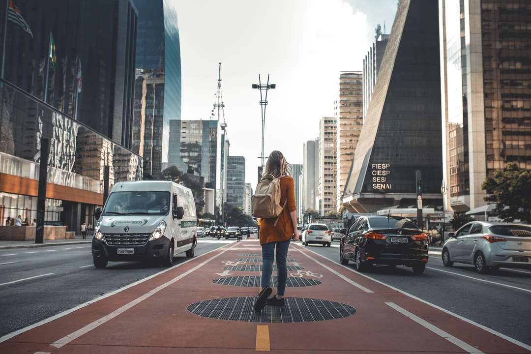 Fotografia kobieta idąca między drogą z pojazdami puzzle online