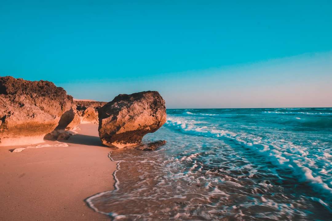 brązowa formacja skalna na brzegu morza w ciągu dnia puzzle online