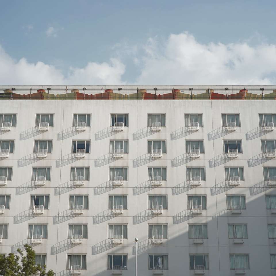 Biały betonowy budynek pod błękitnym niebem podczas dnia puzzle online