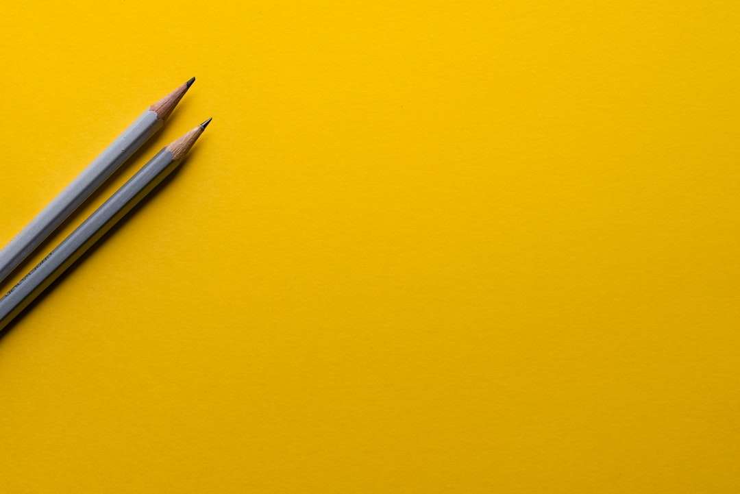 Dwa szare ołówki na żółtej powierzchni puzzle online