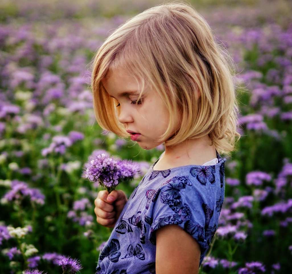 Dziewczyna trzyma purpurowe kwiaty puzzle online