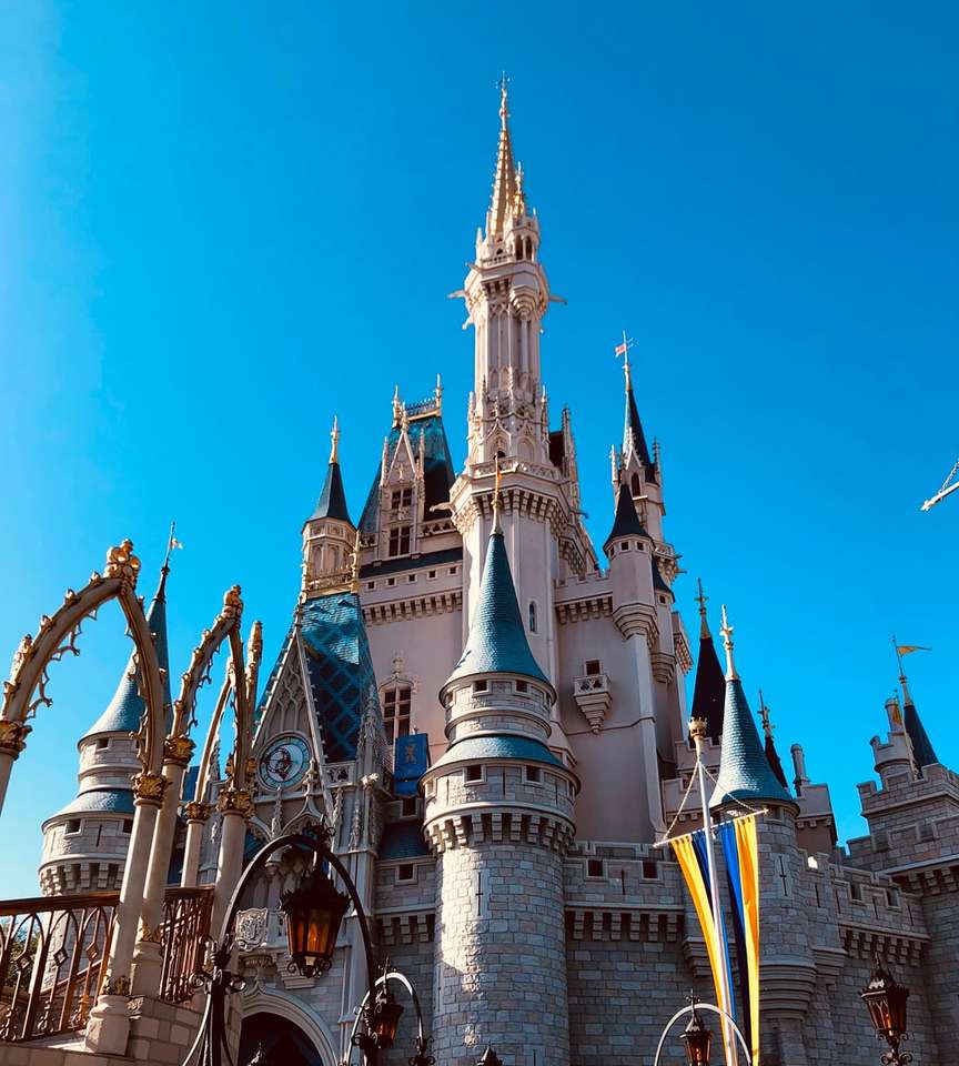 Zamek Disneya pod błękitnym niebem w ciągu dnia puzzle online