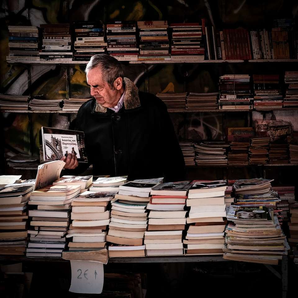 mężczyzna trzymający książkę w pobliżu biblioteki puzzle online