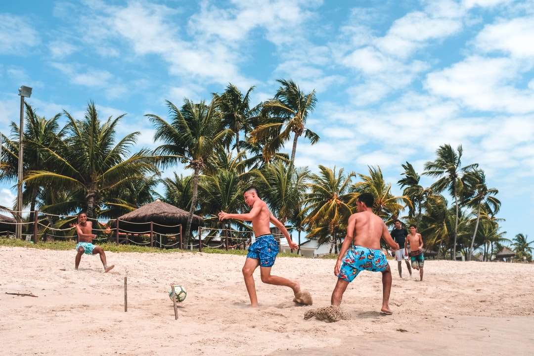 Kilku mężczyzn gra w piłkę nożną na piasku plaży puzzle online
