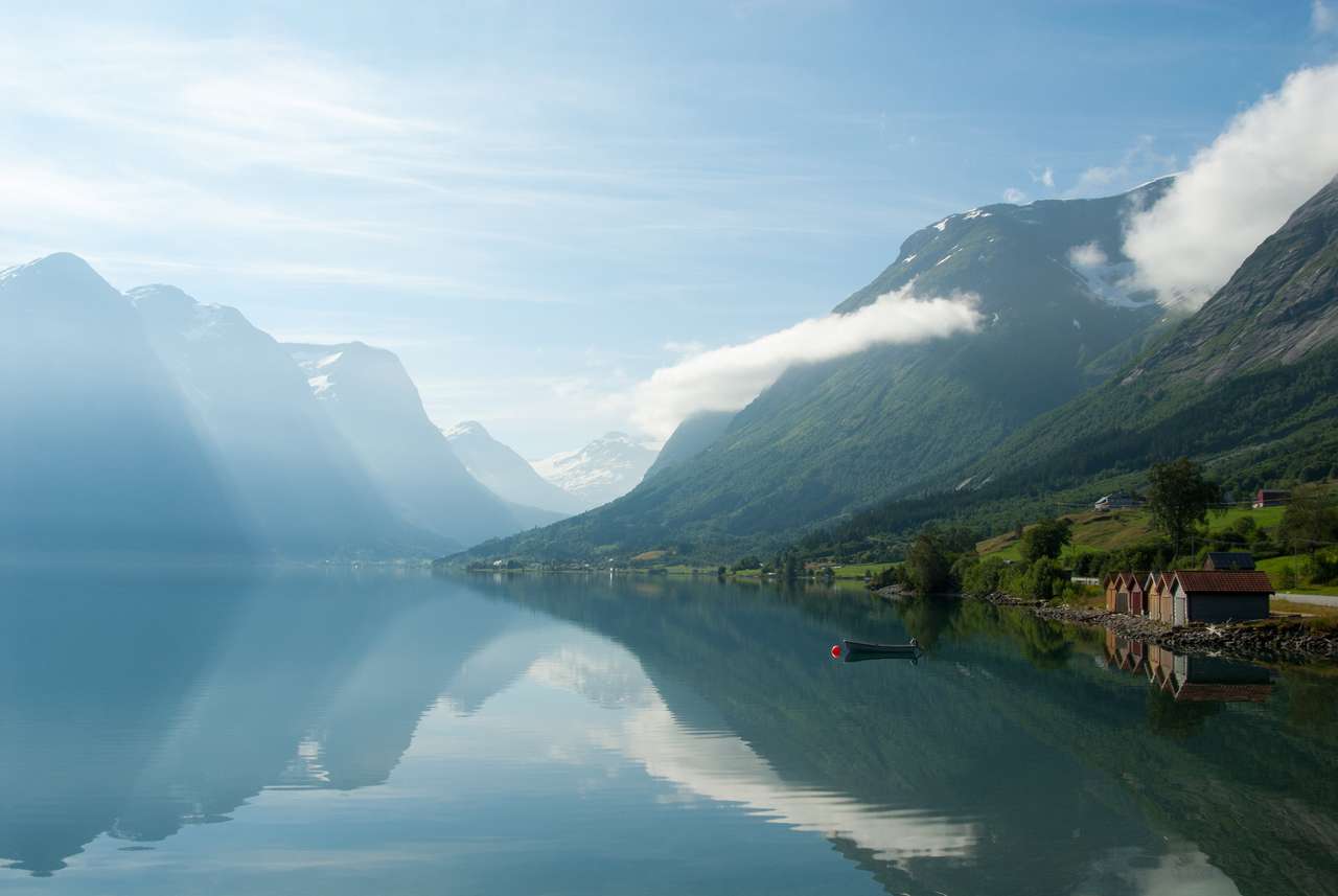 Krajobraz z górami odbijających w jeziorze i małej łodzi blisko brzegu, Norwegia puzzle online