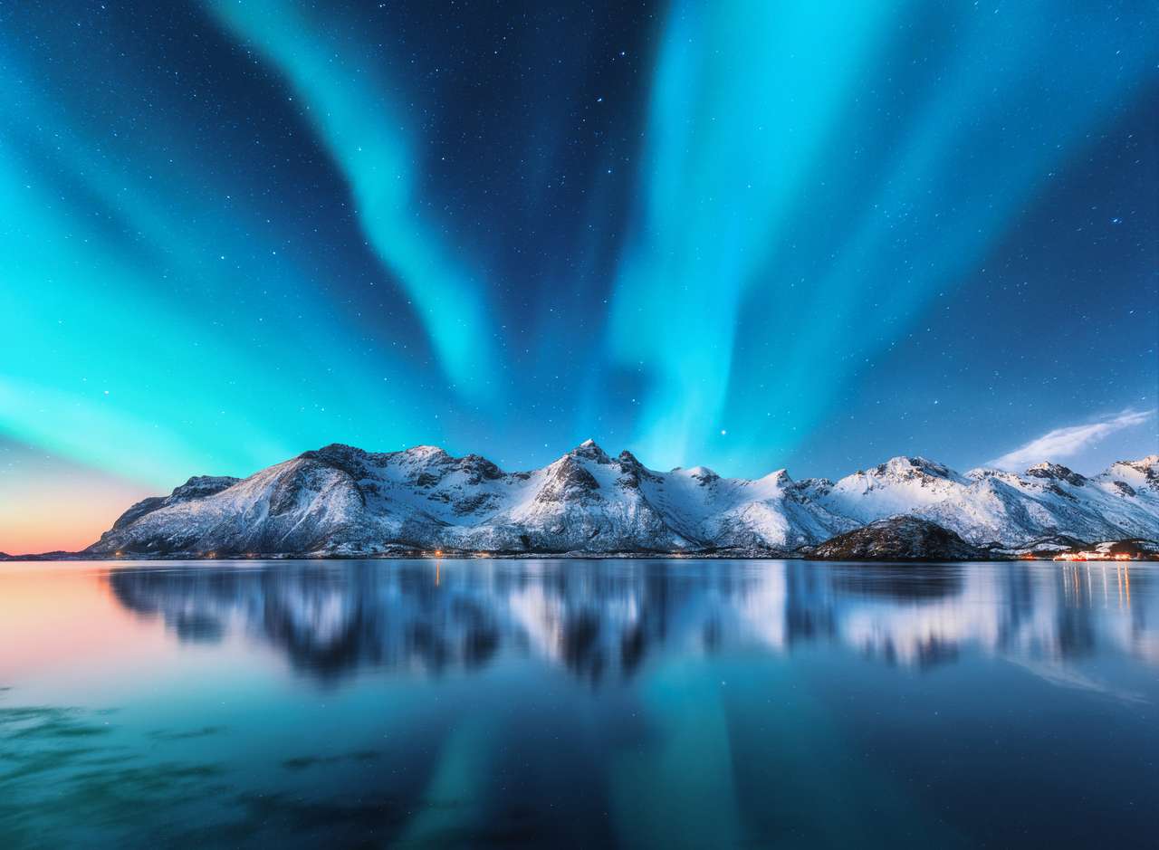 Północne światła i śnieg pokryte górami w Lofotenach, Norwegia. Aurora Borealis. Gwiaździste niebo z światłami polarnymi i śnieżnymi skałami odbijającymi w wodzie. Noc zimowy krajobraz z Aurora, morze. Natura puzzle online