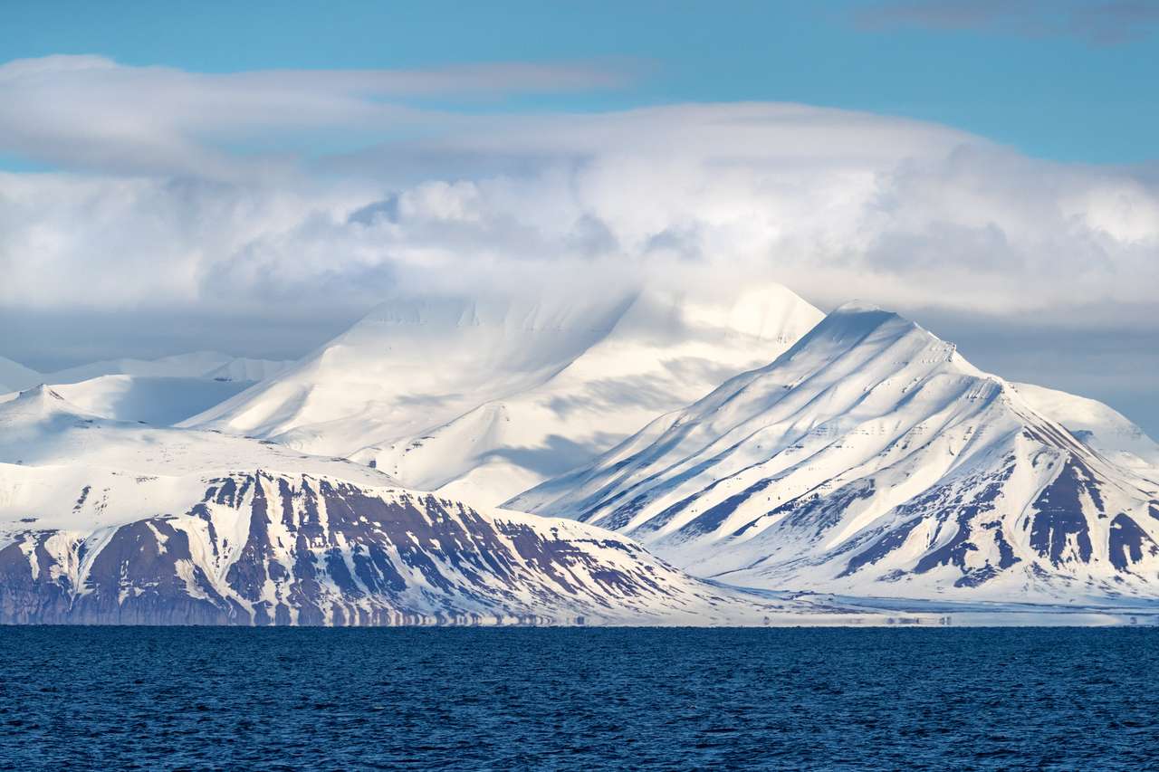Nieskazitelne i nietknięte śniegowe góry svalbard rosnących z lodowatych wód niebieskich fjordu. Svalbard jest norweskim archipelagiem między Norwegimatycznym a Północnym. puzzle online