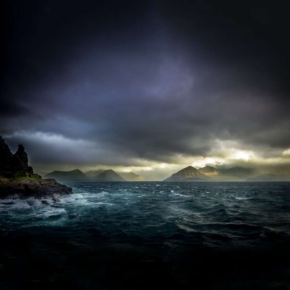 Zdjęcie krajobrazu wód, gór i czarnych chmur puzzle online