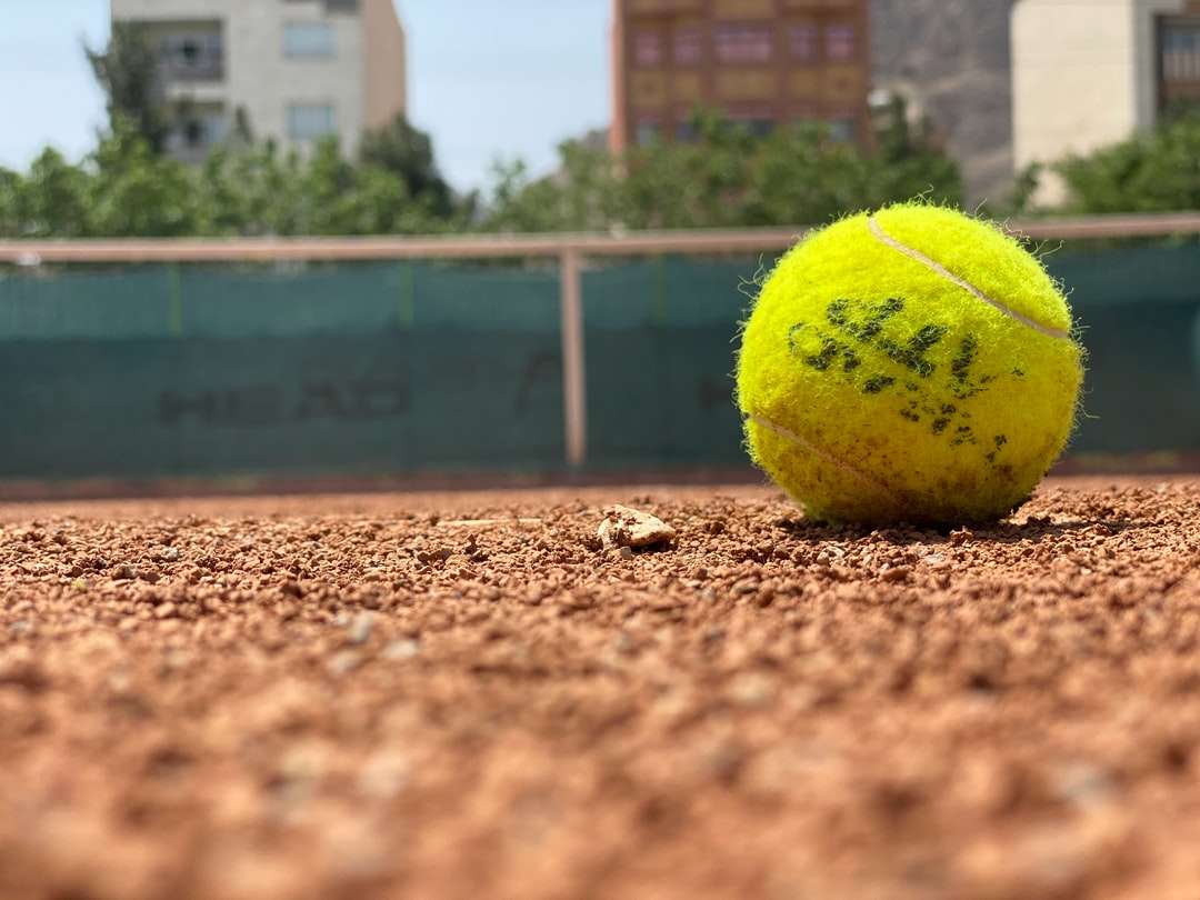 Zielona piłka tenisowa na brown glebie w ciągu dnia puzzle online