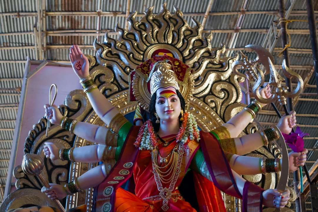 posąg hinduskiego bóstwa przed brązowym budynkiem puzzle online
