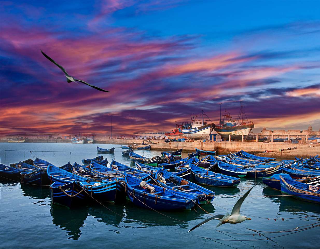 Niebieskie łodzie rybackie na wybrzeżu oceanu w Essaouira, Maroko puzzle online