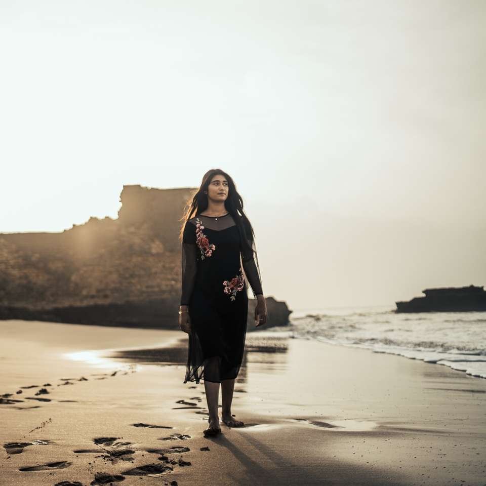 kobieta stojąca na brzegu podczas zachodu słońca puzzle online