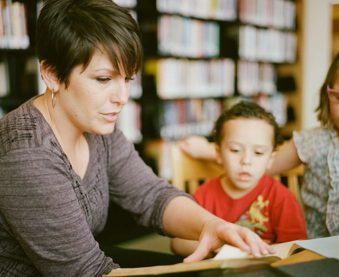 kobieta w szarej koszuli z długim rękawem siedząca obok chłopca puzzle online