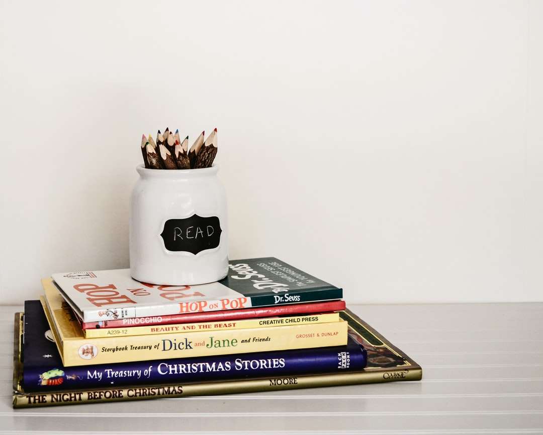 biały ceramiczny organizer na ołówki na górze stosu książek puzzle online