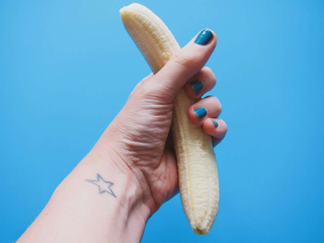 osoba trzymająca obrane owoce bananowe puzzle online