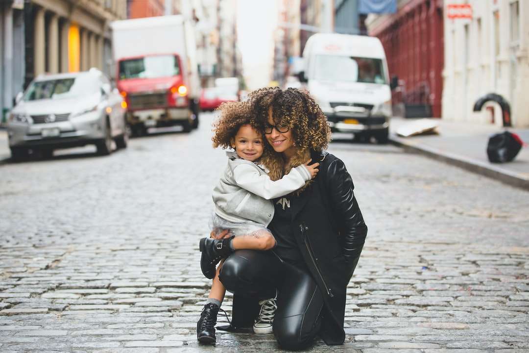 fotografia kobiety niosącej dziecko w pobliżu ulicy puzzle online