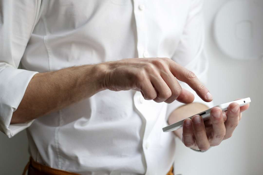 osoba trzymająca biały smartfon z Androidem w białej koszuli puzzle online
