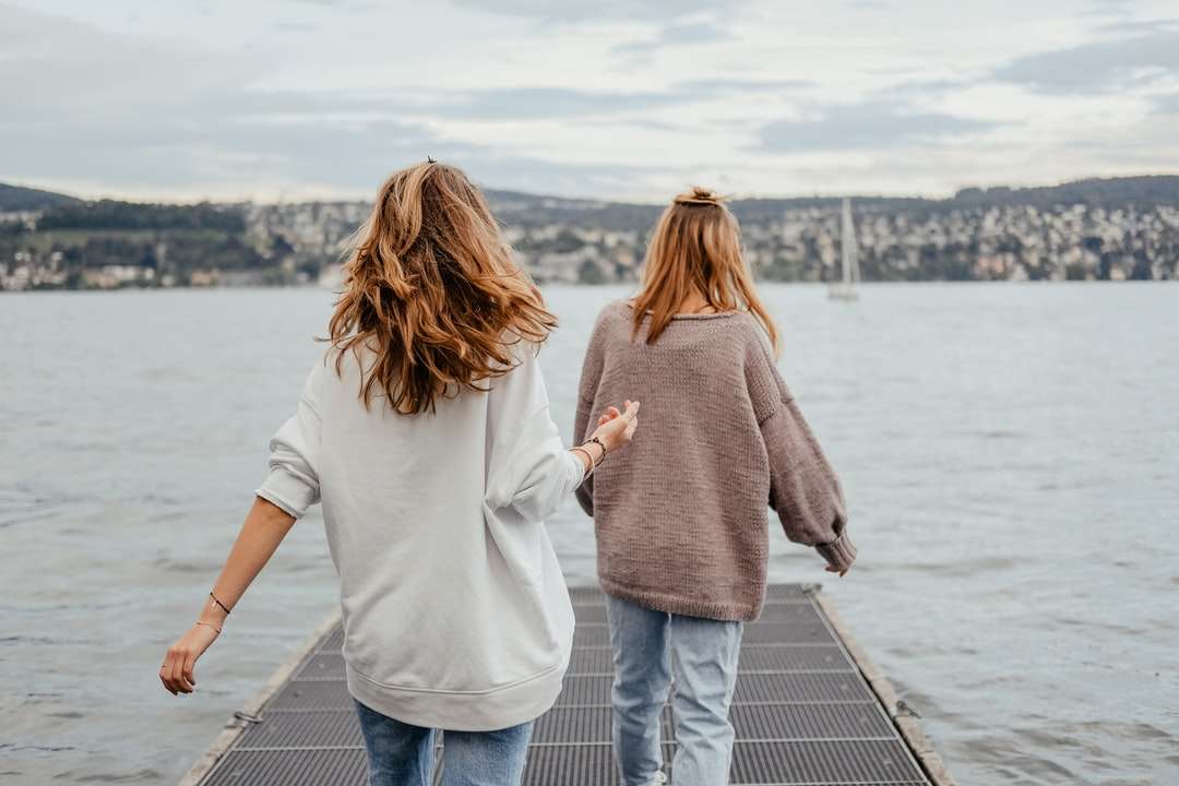 dwie kobiety stojące w porcie nad brzegiem morza w ciągu dnia puzzle online
