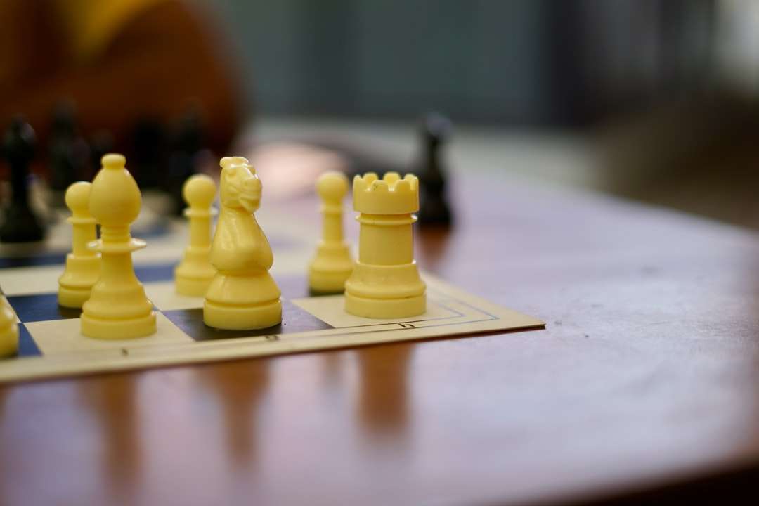 żółty plastikowy pionek szachowy na białym stole puzzle online