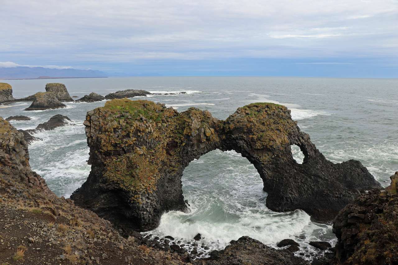 Naturalna brama skalna, która wznosi się z morza na Islandii puzzle online