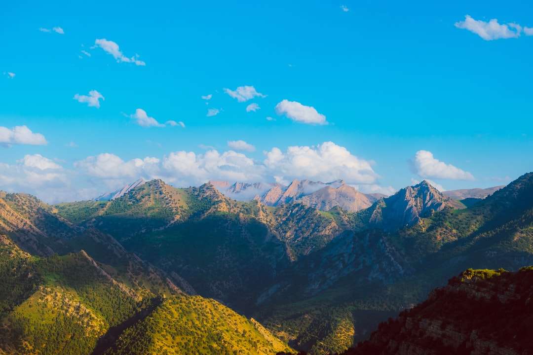 zielone i brązowe góry pod błękitnym niebem w ciągu dnia puzzle online