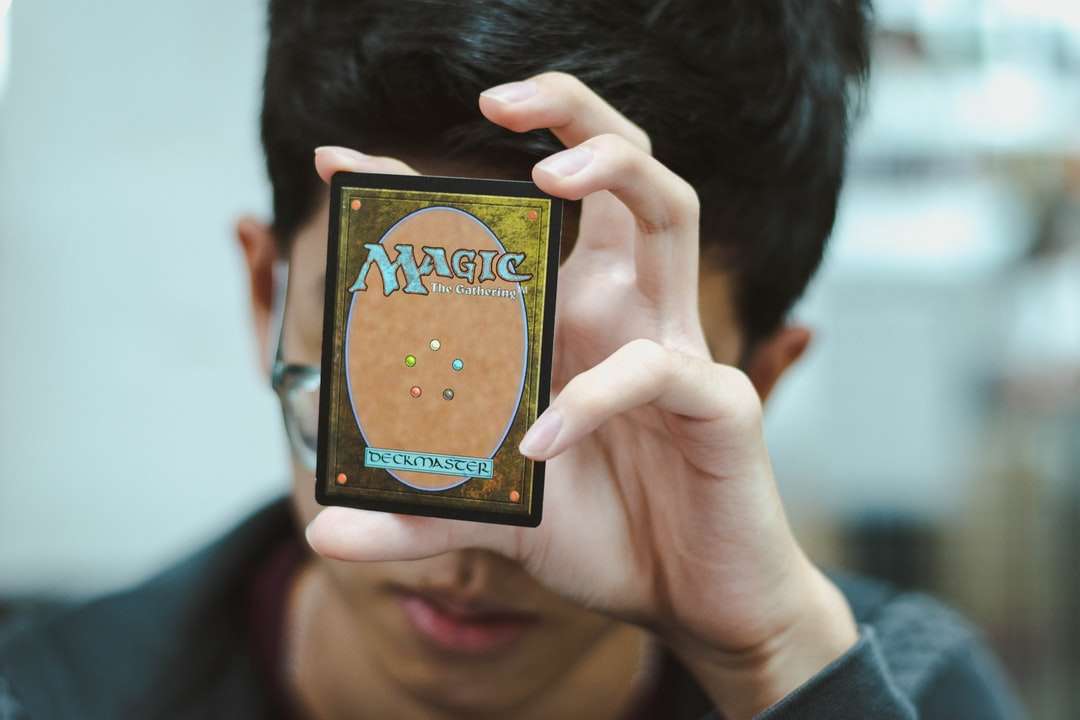 chłopiec trzymający kartę kolekcjonerską Magic: The Gathering puzzle online