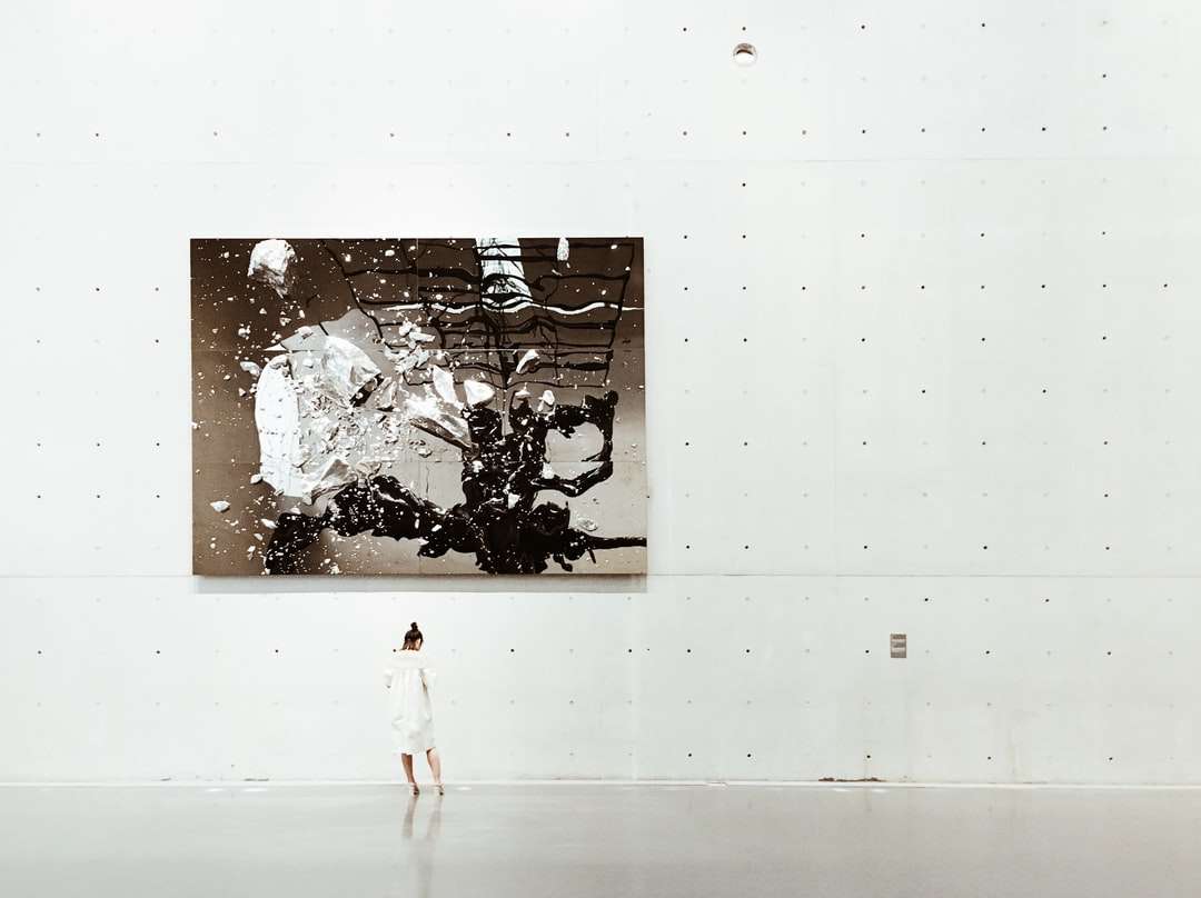 Kobieta stojąca obok obrazu w galerii sztuki współczesnej puzzle online