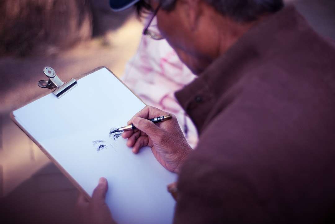 mężczyzna szkicujący twarz na białym papierze do drukarki puzzle online