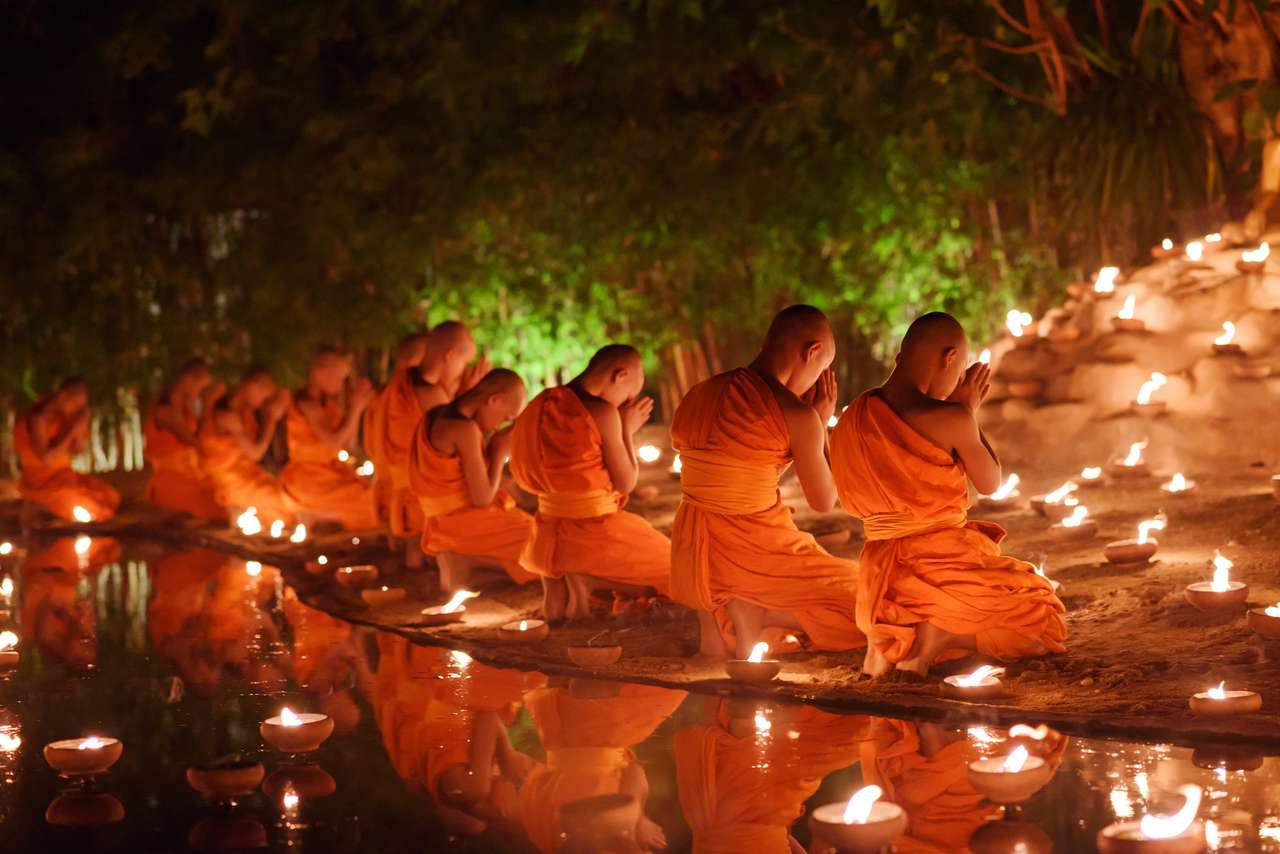 mnisi siedzący medytują z wieloma świecami w tajskiej świątyni w nocy, Chiangmai, Tajlandia, nieostrość puzzle online