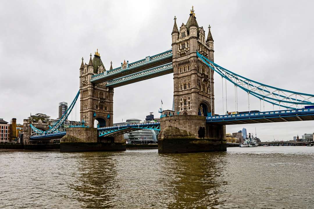 brązowy betonowy most nad rzeką pod białymi chmurami puzzle online