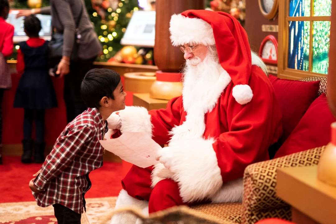 chłopiec stojący przed mężczyzną w kostiumie Świętego Mikołaja puzzle online