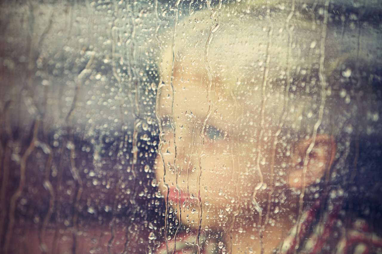 Mały chłopiec za oknem w deszczu puzzle online