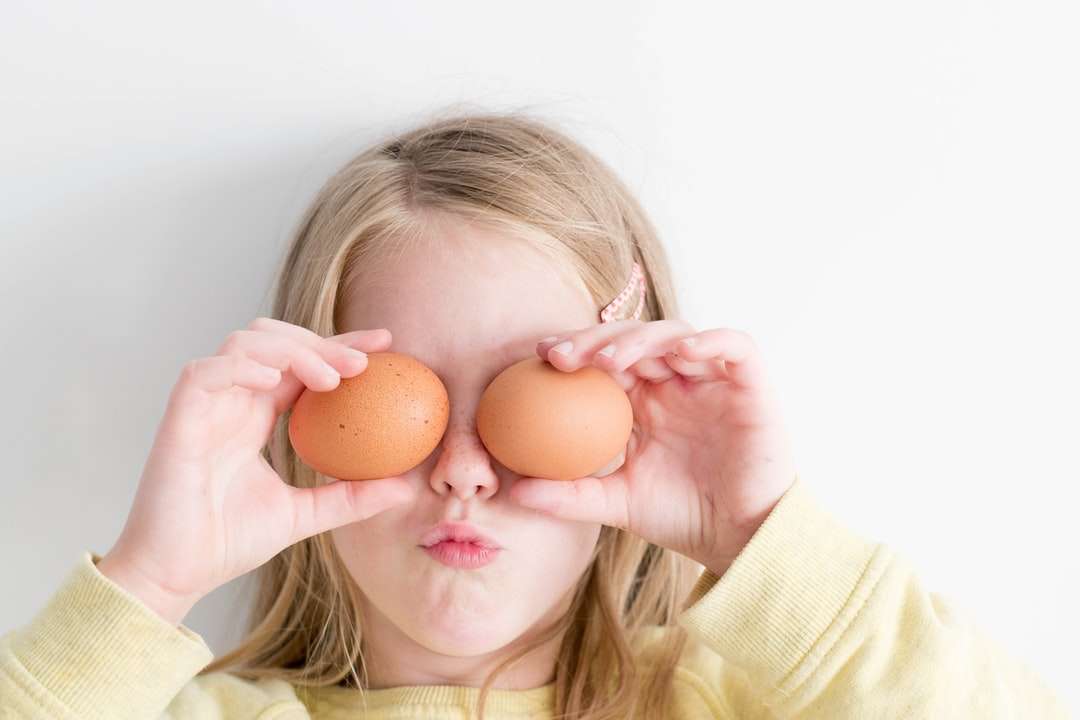 dziewczynka trzymająca dwa jajka podczas nakładania go na oczy puzzle online